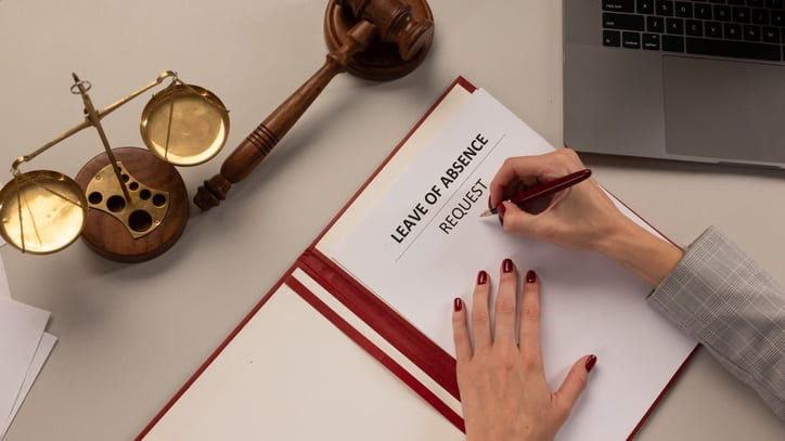 A woman writing a legal document on a desk.