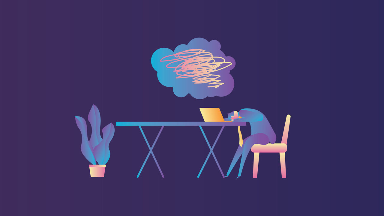 A person sitting at a table with a laptop in front of him.