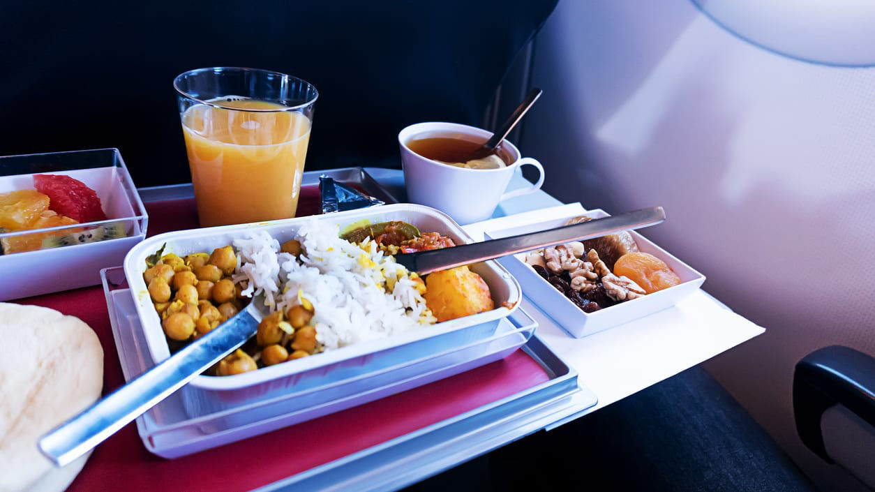 A tray with food and drinks on an airplane.
