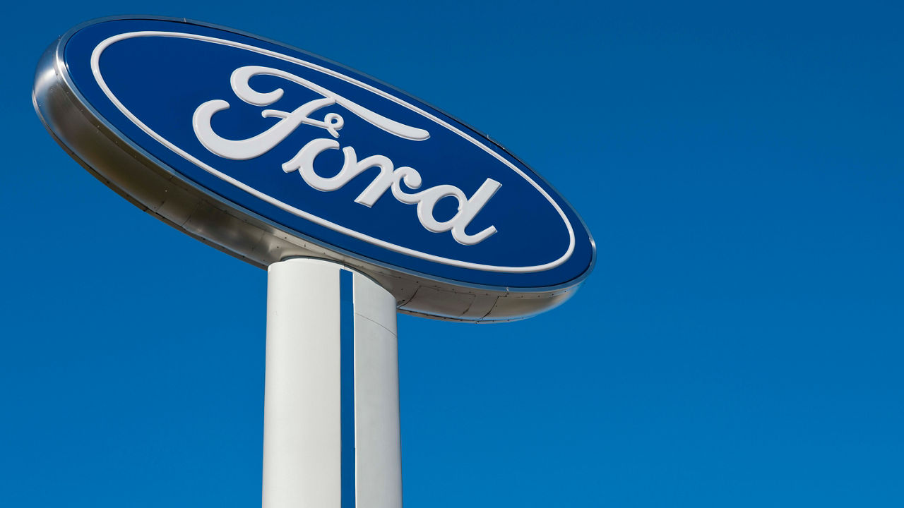 A ford sign is shown against a blue sky.