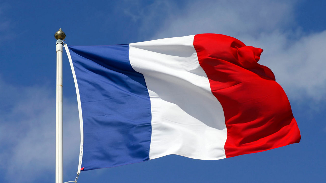 The flag of france is flying in the wind.