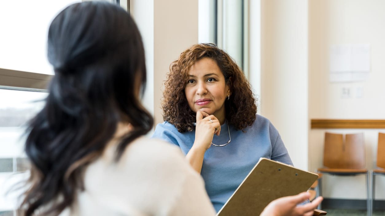 A woman talking to a woman in a waiting room.