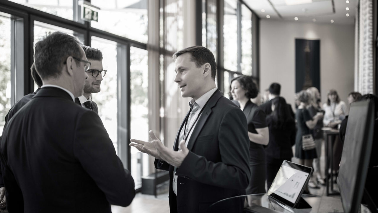 A group of business people talking at an event.