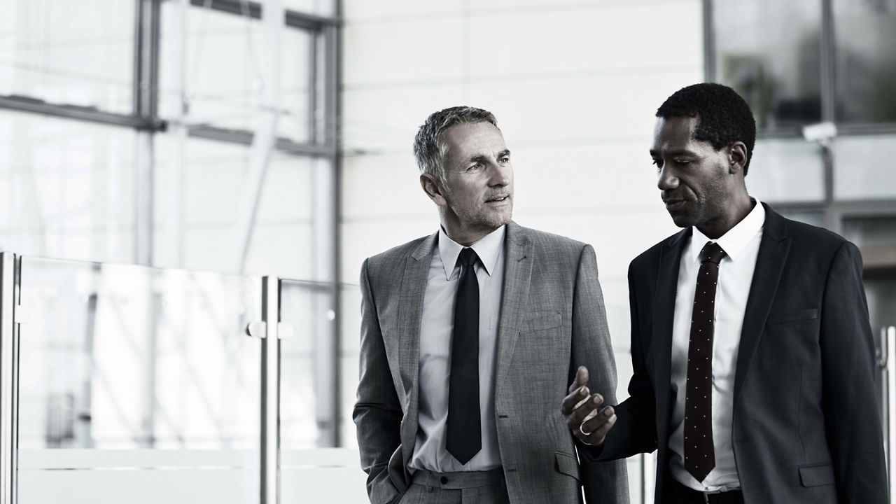 Two business men talking in an office building.