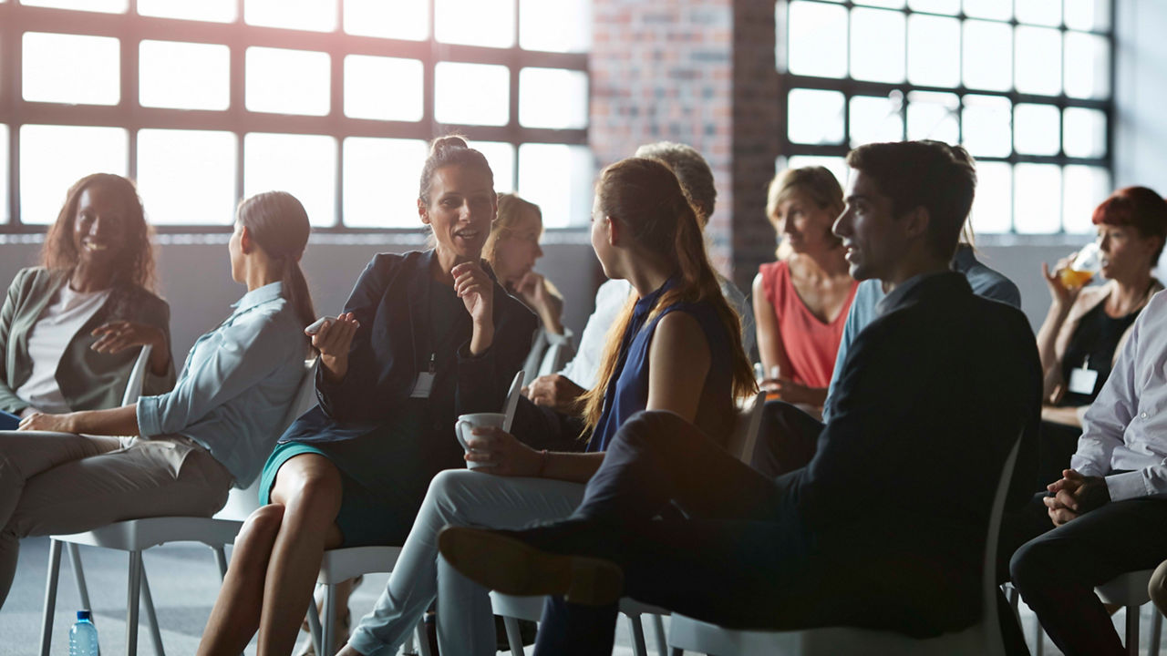 A group of people sitting in chairs at a conference.