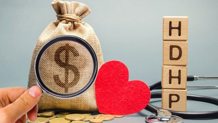 A hand holding a stethoscope and a bag of money with the word hdhp.