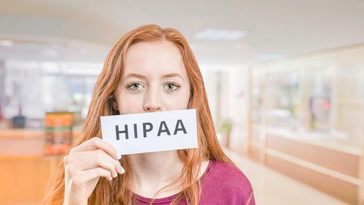 A woman holding up a sign that says hipaa.