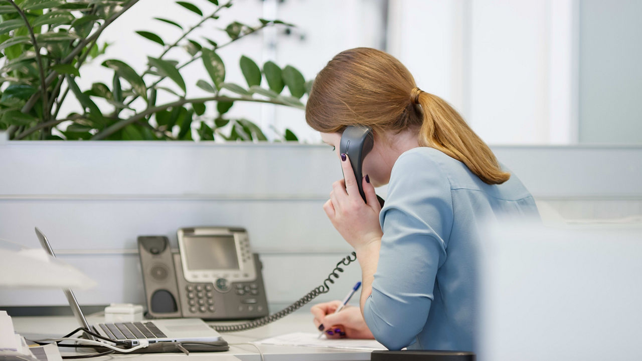 A woman talking on the phone in an office.