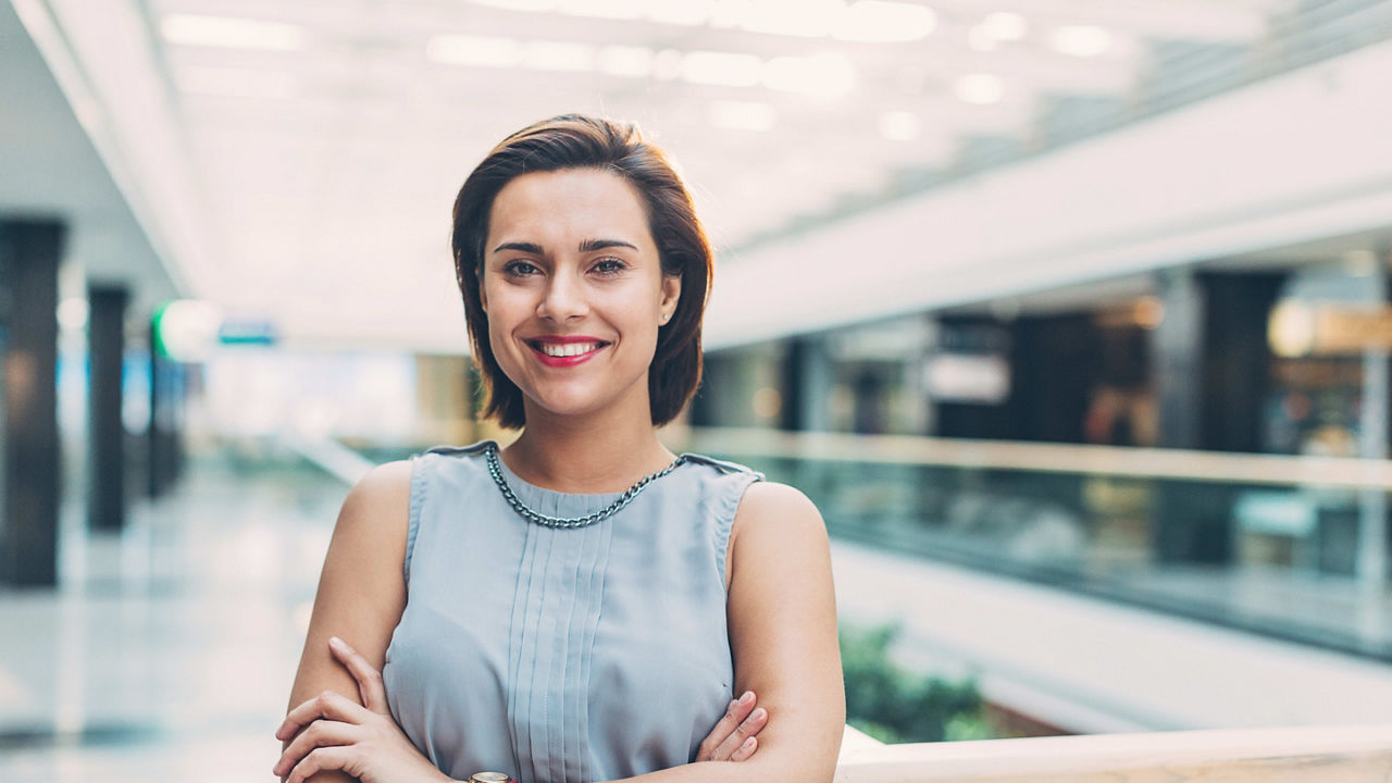 A smiling business woman standing in an office building.