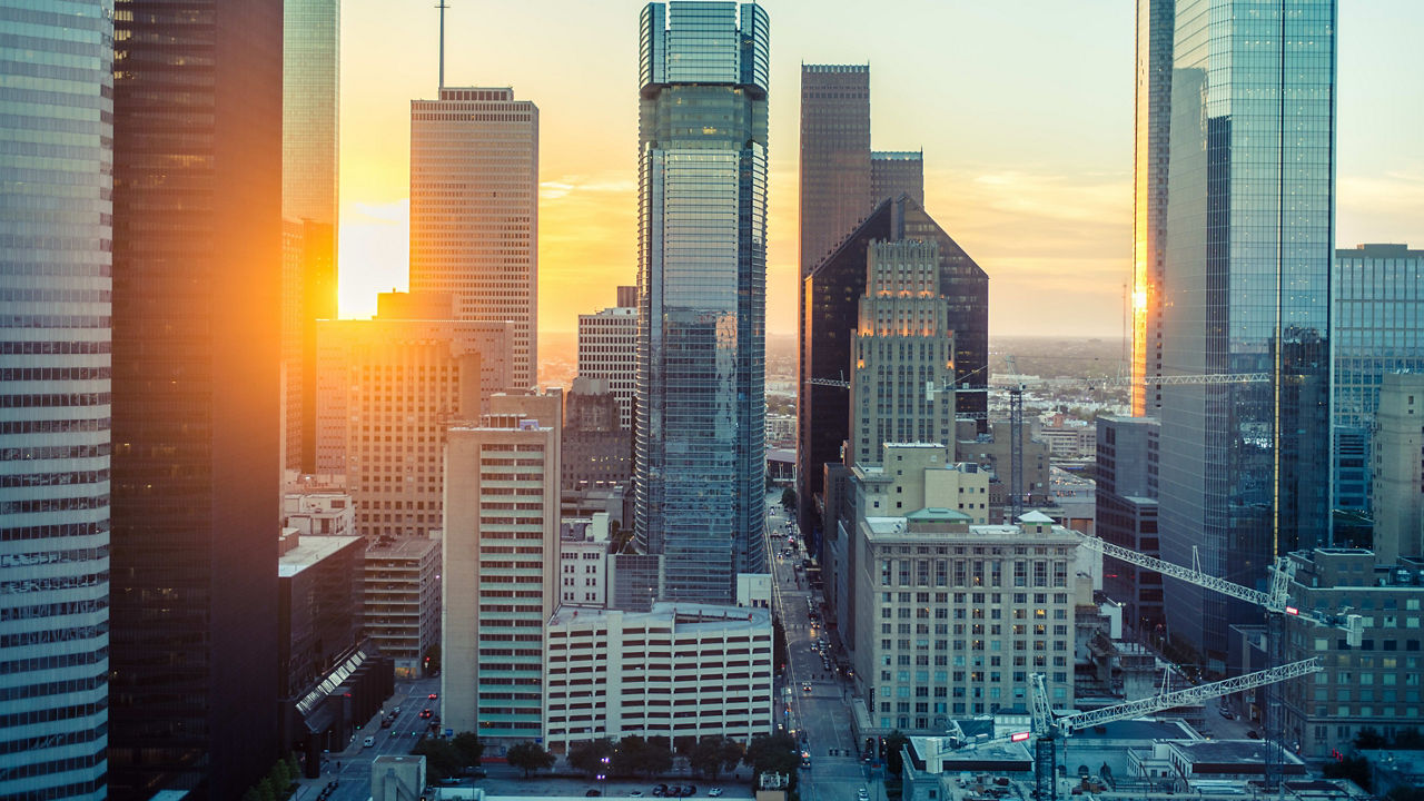 The sun is setting over a city with tall buildings.