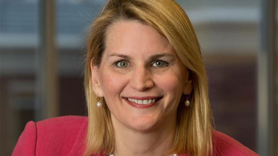 A woman in a pink jacket smiling for the camera.