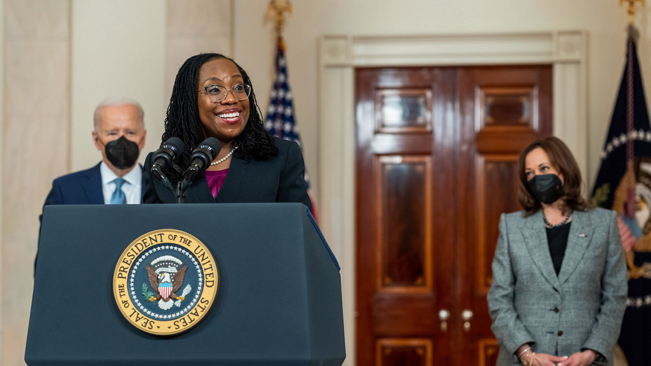 Two women standing at a podium with masks on.