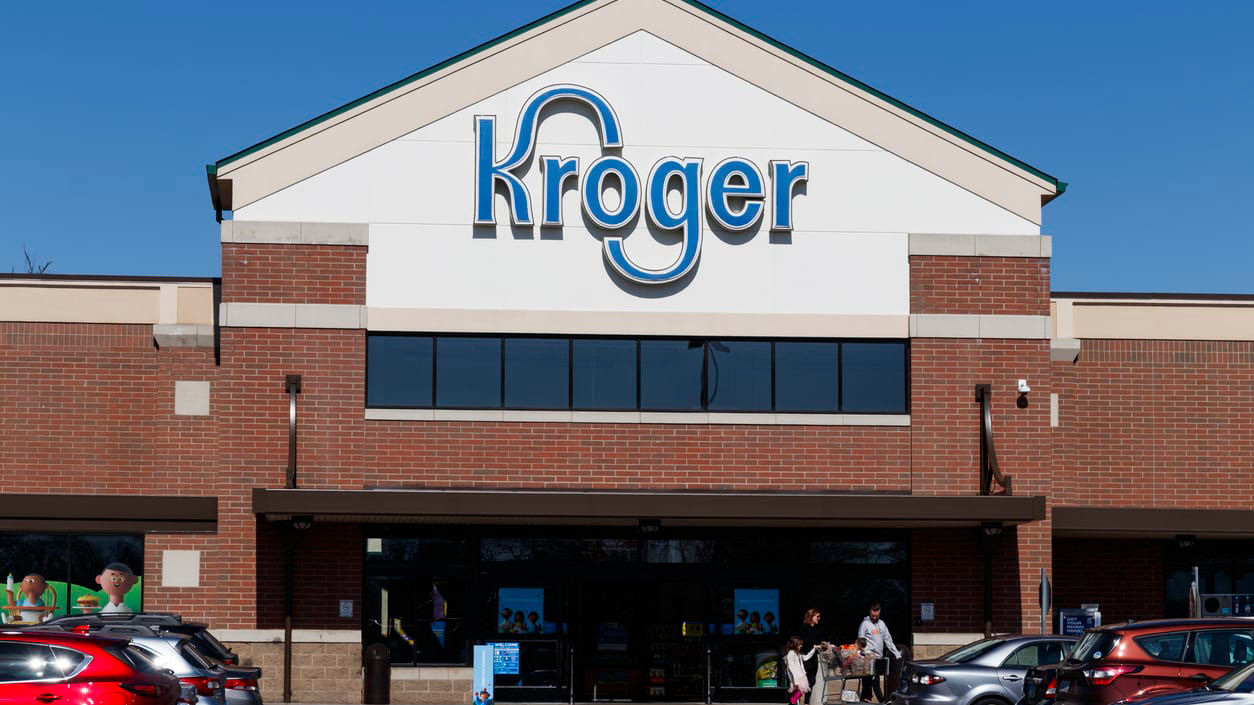 A kroger store with cars parked in front of it.