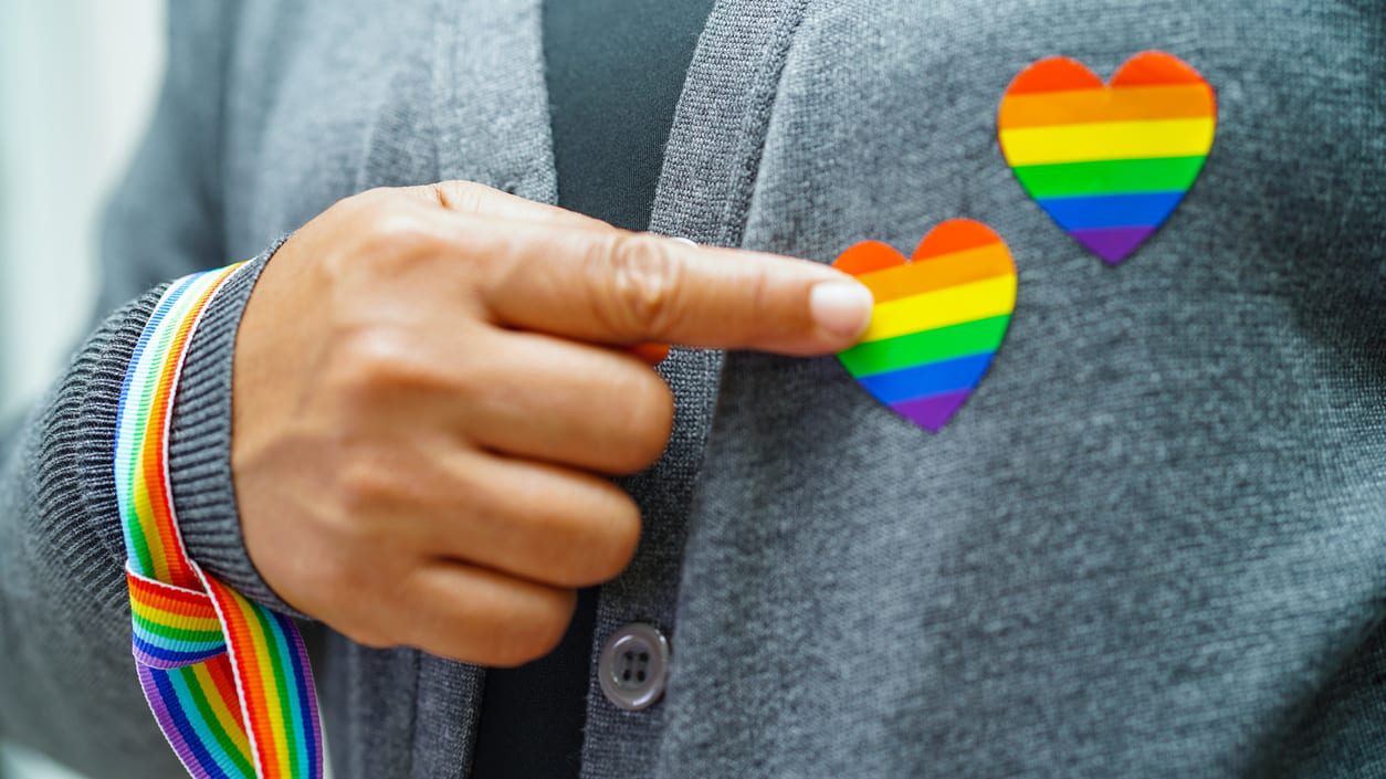 pride hearts on lapel with finger pointing to them