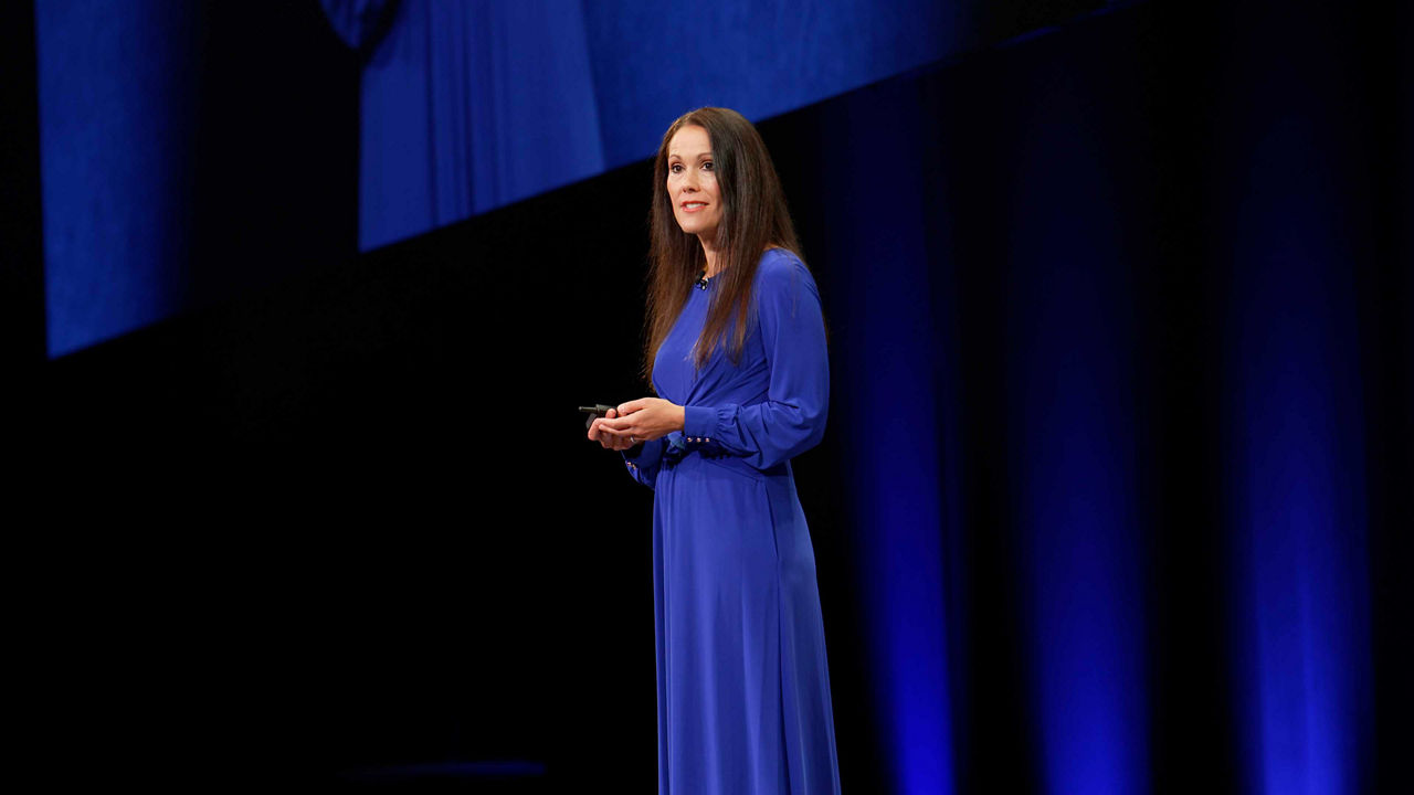 A woman in a blue dress standing on stage.