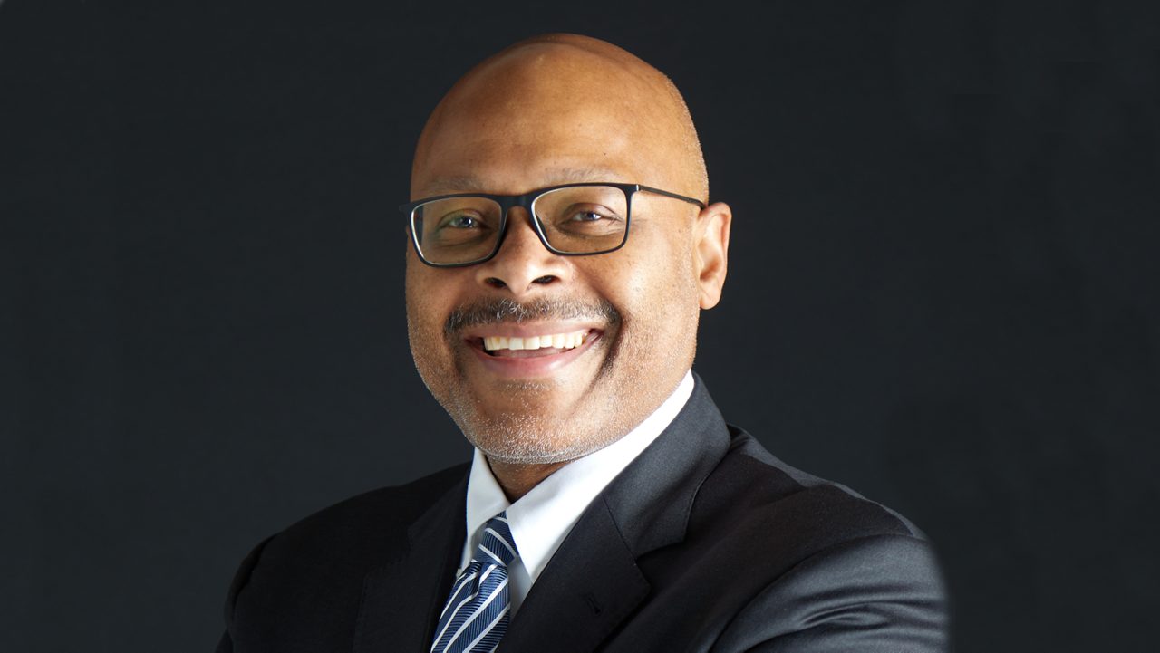 A man in a suit and tie smiling.