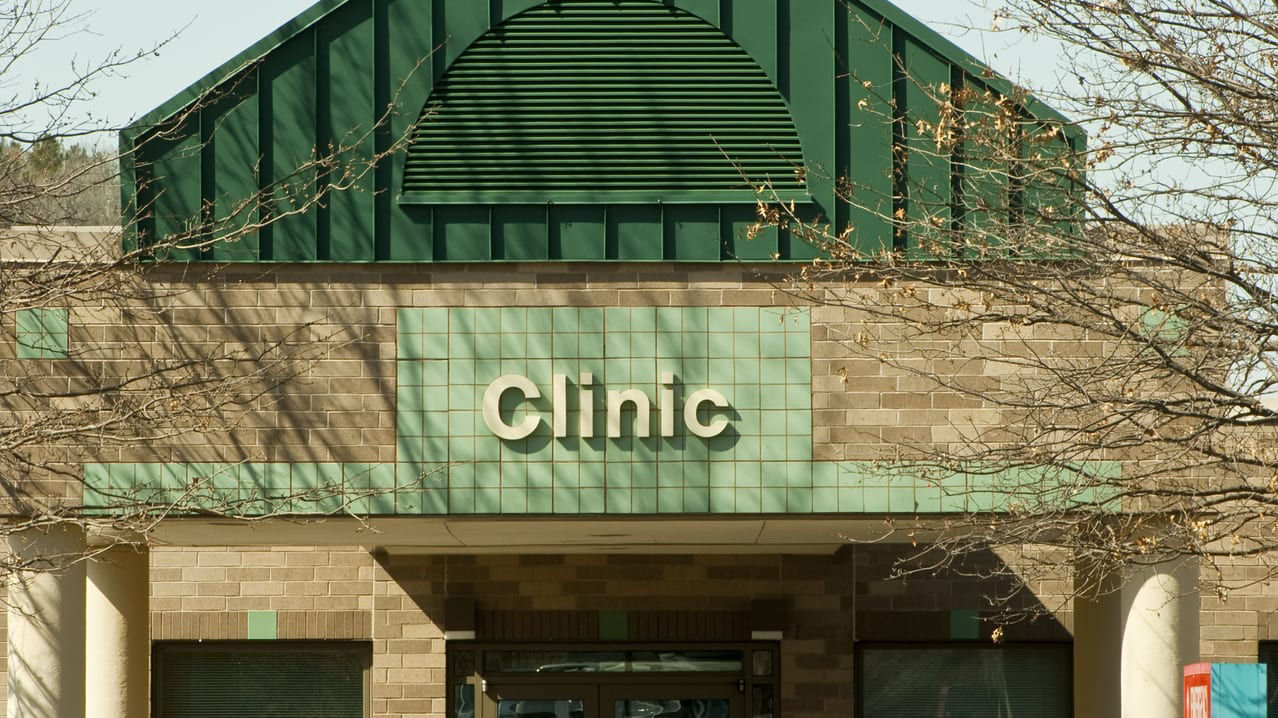 A building with a green roof and a sign that says clinic.