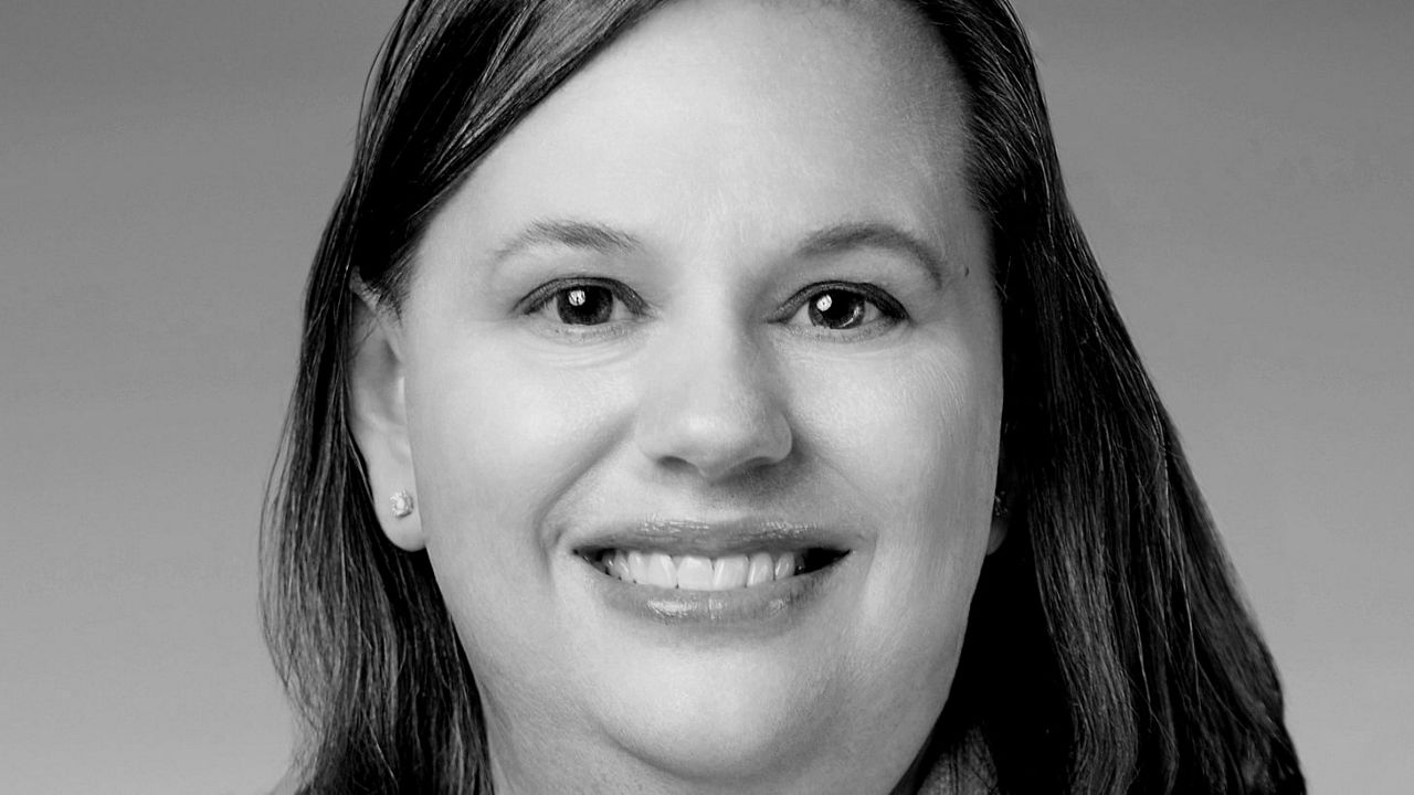 A black and white photo of a woman in a suit.