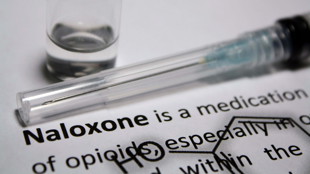 A syringe with the word naloxone next to it.