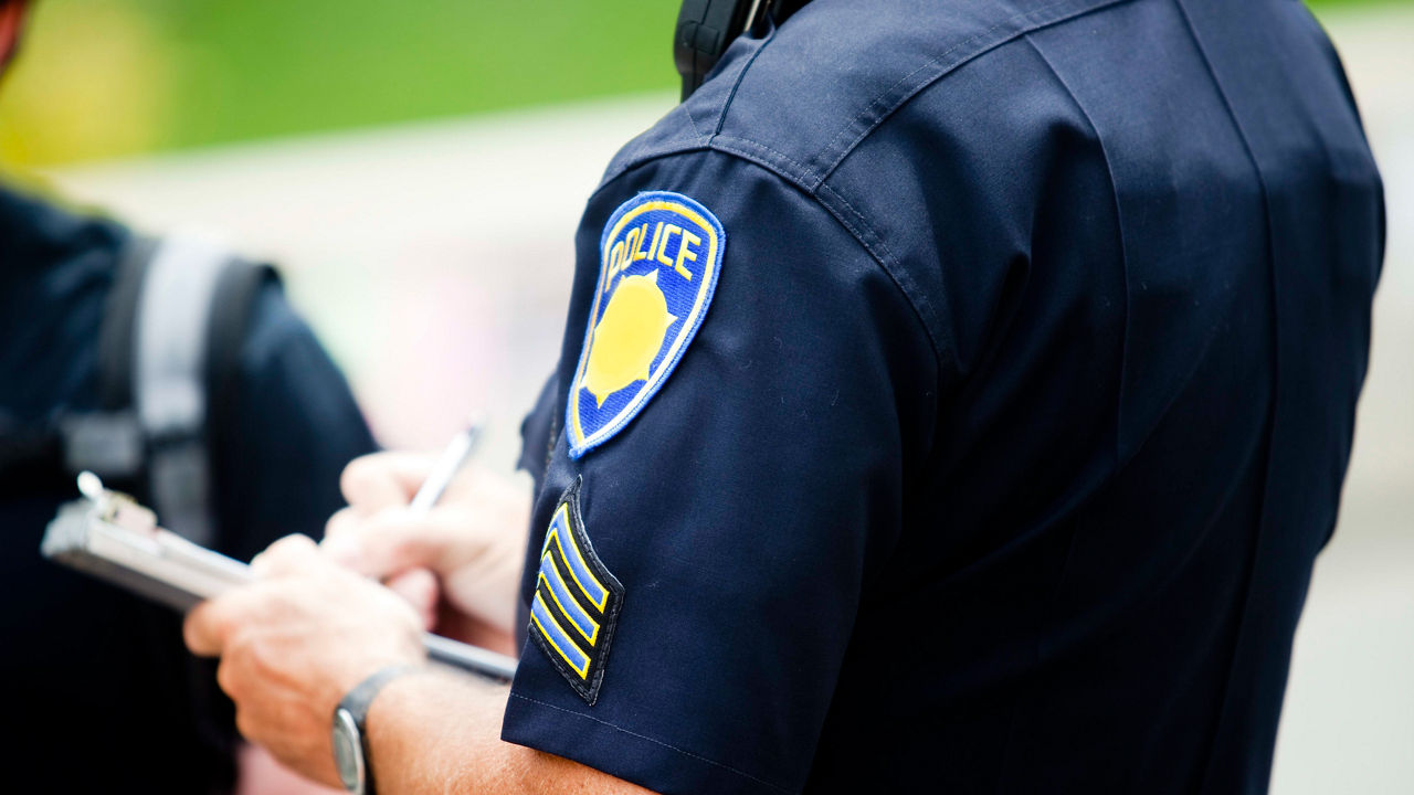 A police officer is looking at a clipboard.