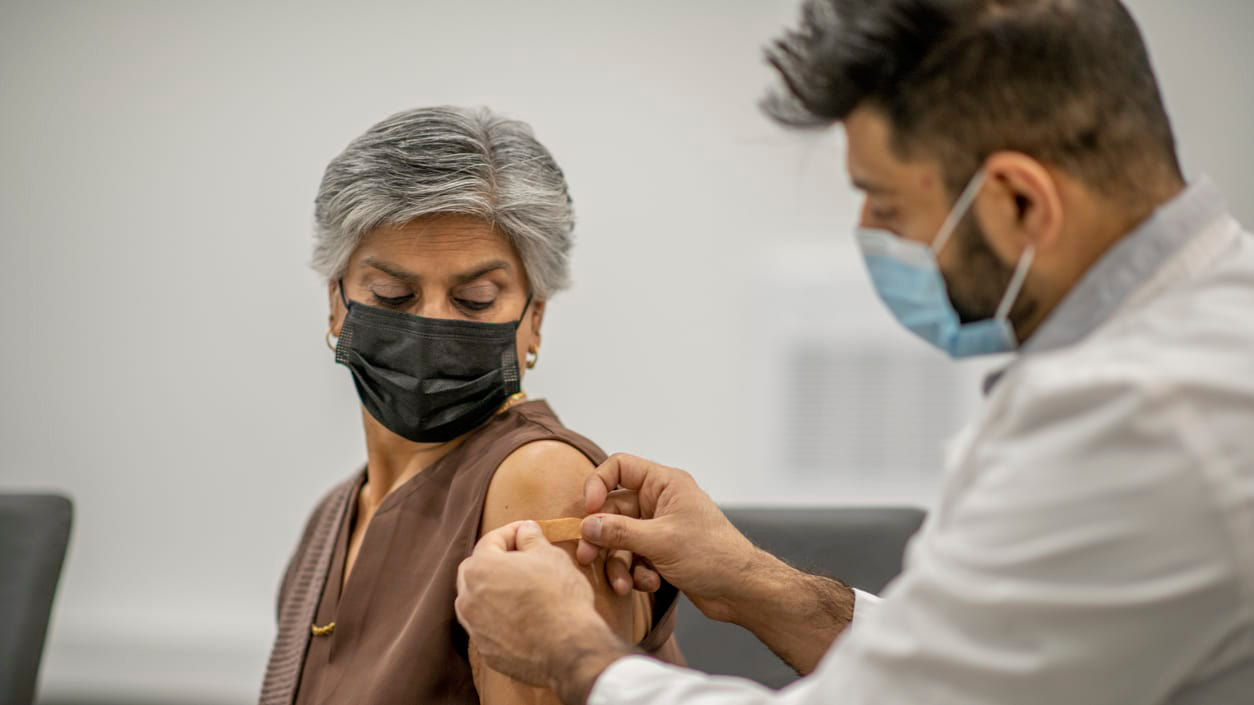 A woman is getting a vaccine in a doctor's office.