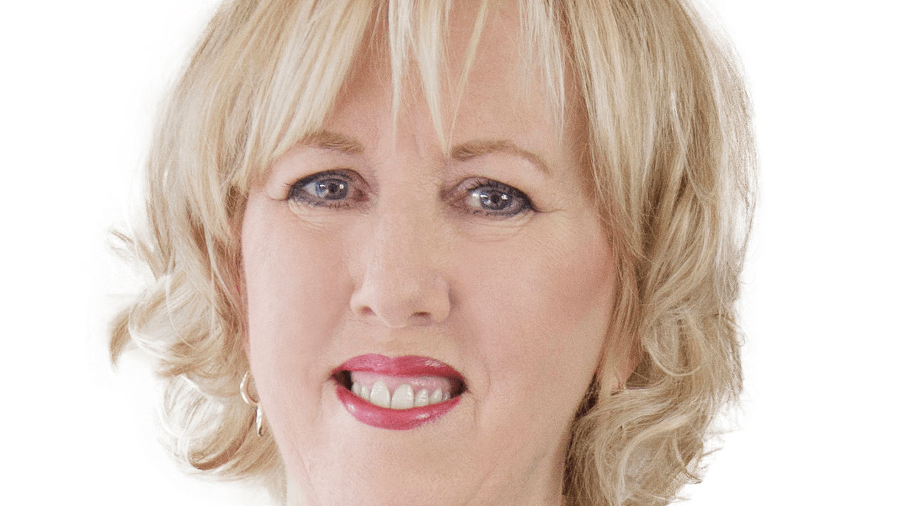 A woman in a leopard print shirt is posing for a photo.