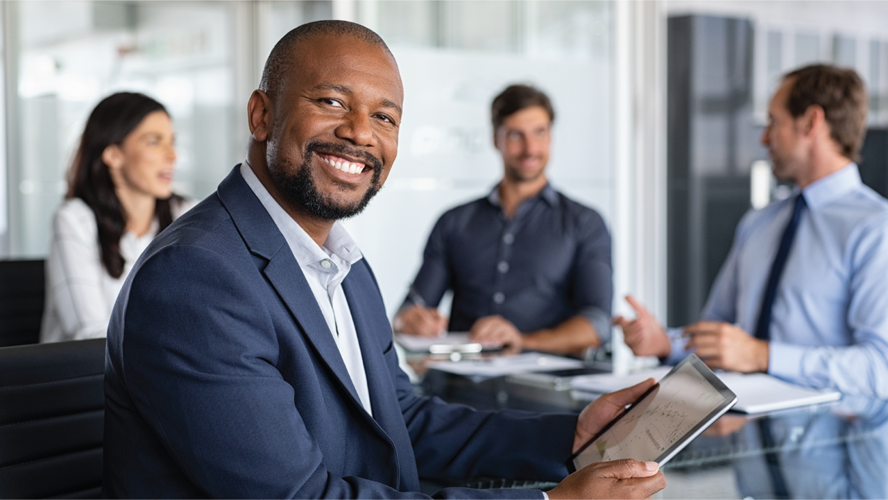 Smiling man with coworkers in background