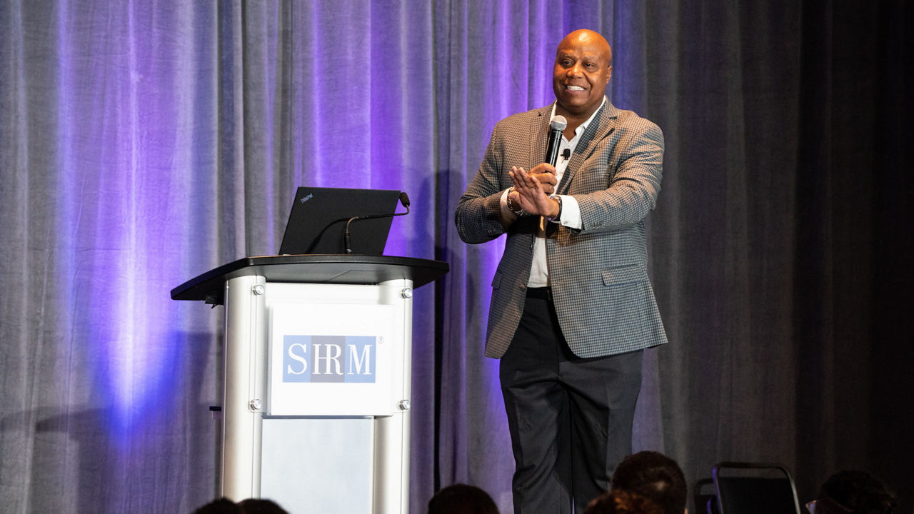A man standing at a podium in front of a crowd.
