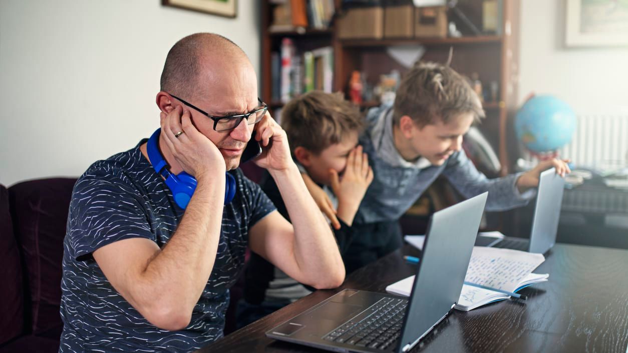 A man and his son are sitting at a table with a laptop.