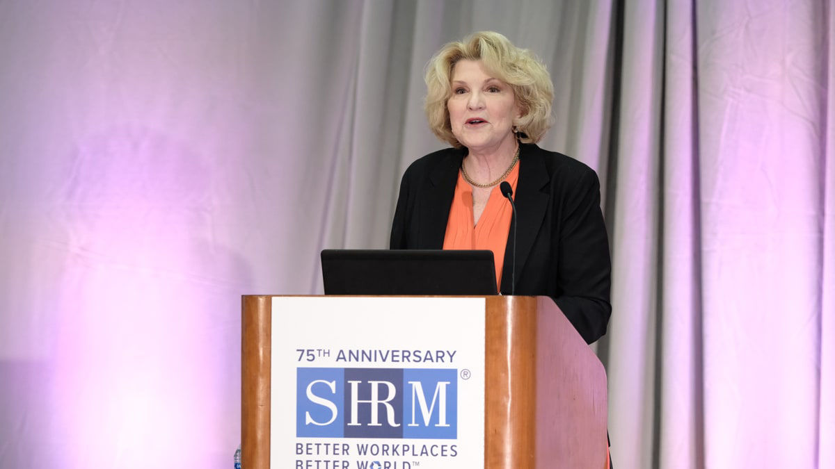 A woman giving a speech at a podium.