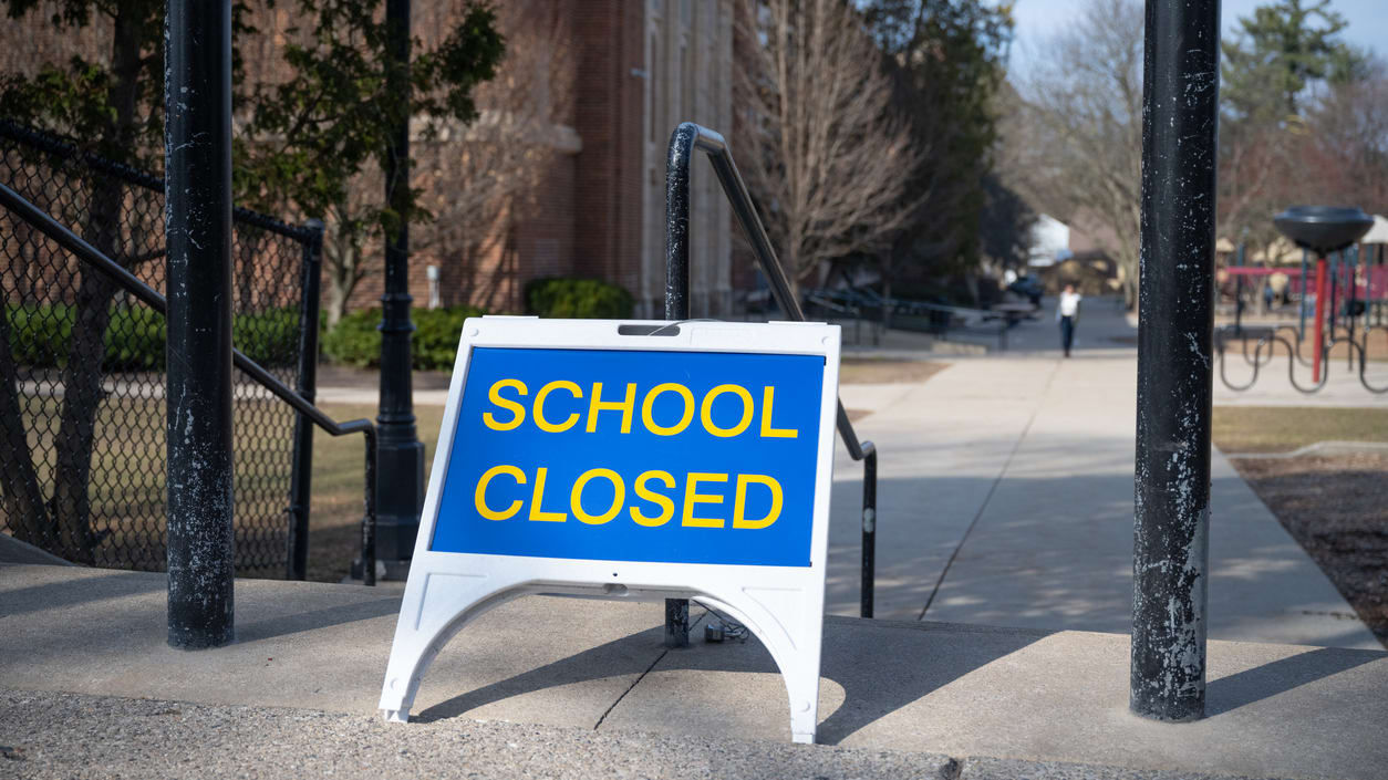 A school closed sign in front of a building.