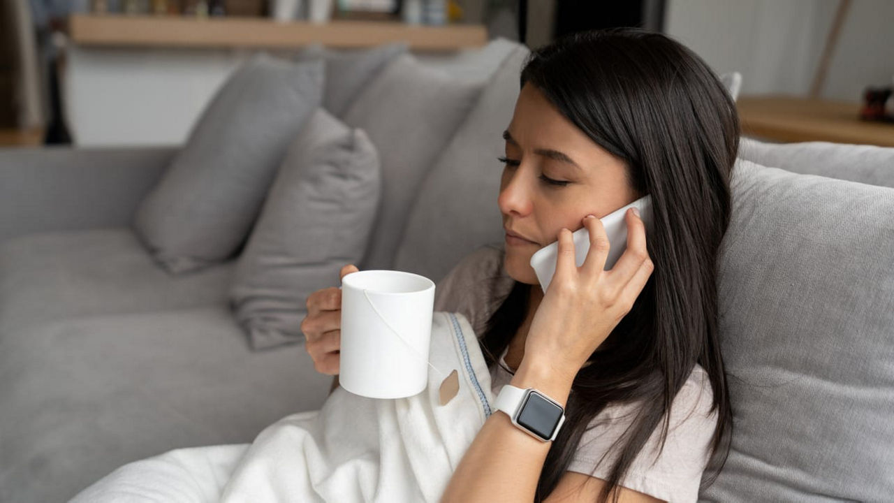 A woman talking on the phone while sitting on a couch.