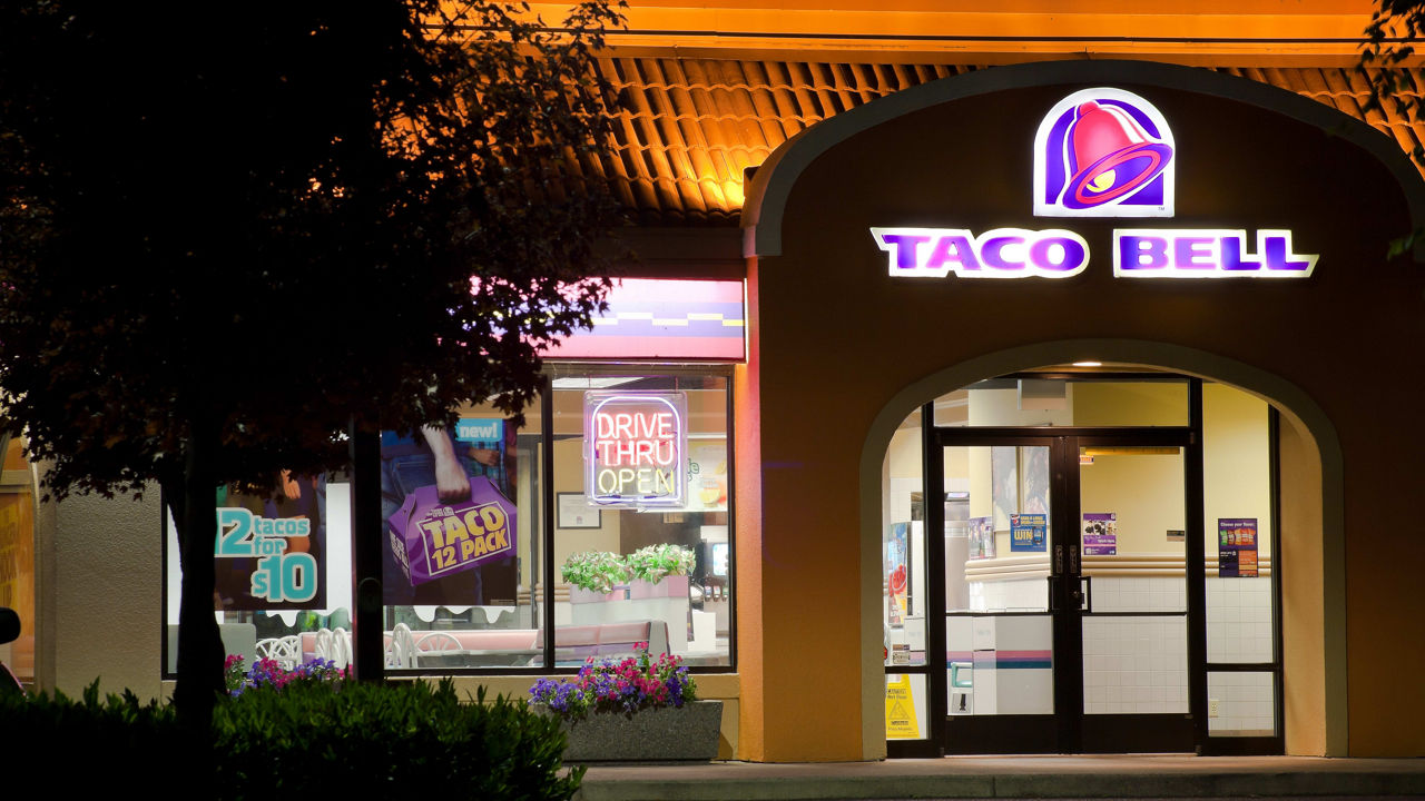 A taco bell restaurant is lit up at night.