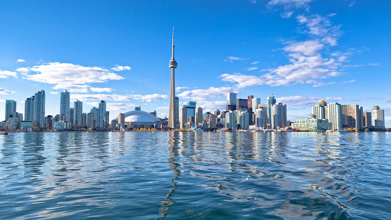 Toronto skyline reflected in the water on a sunny day.