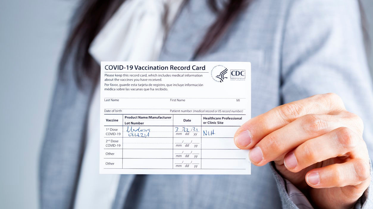 A woman holding up a card with the word cdc.