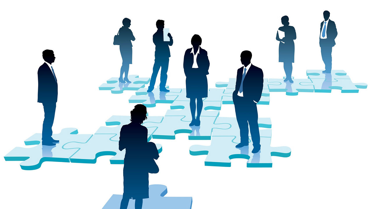 A group of business people standing around a jigsaw puzzle.