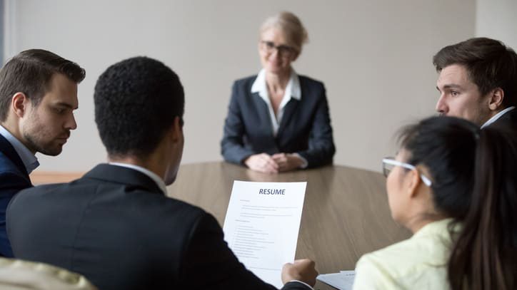 A group of people sitting around a table in a meeting.