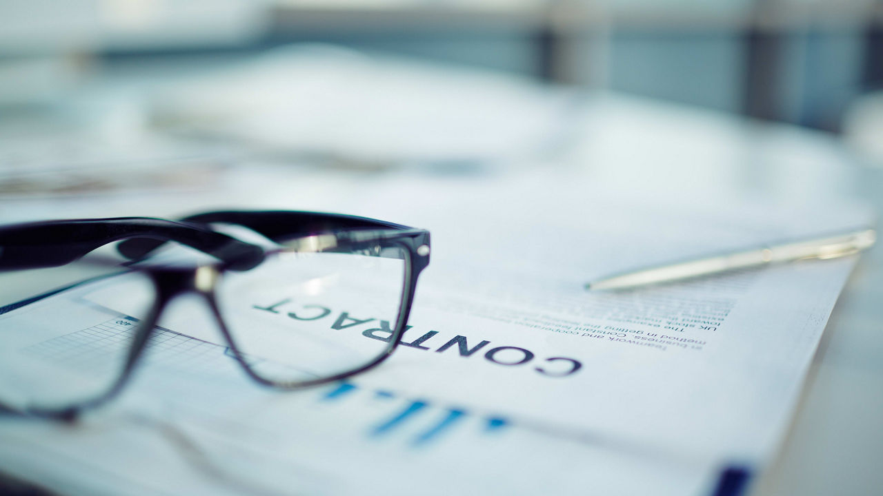 A pair of glasses sits on top of a piece of paper.
