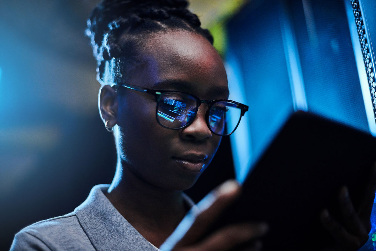 Female worker wearing glasses and looking down at tablet