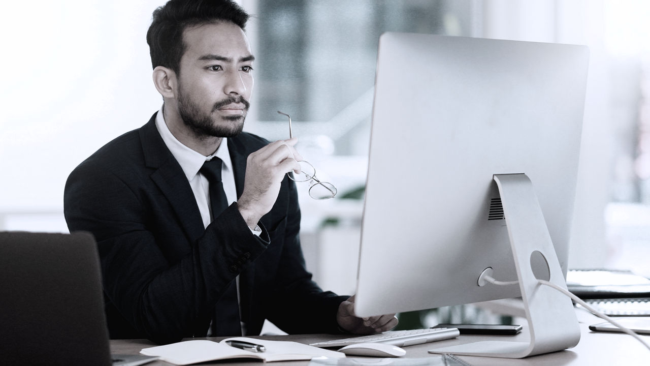 Business executive sitting at desk looking at computer