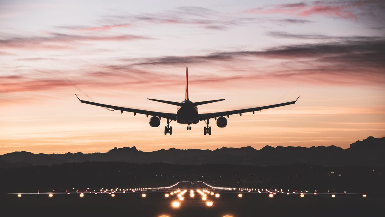 A plane landing at dusk.