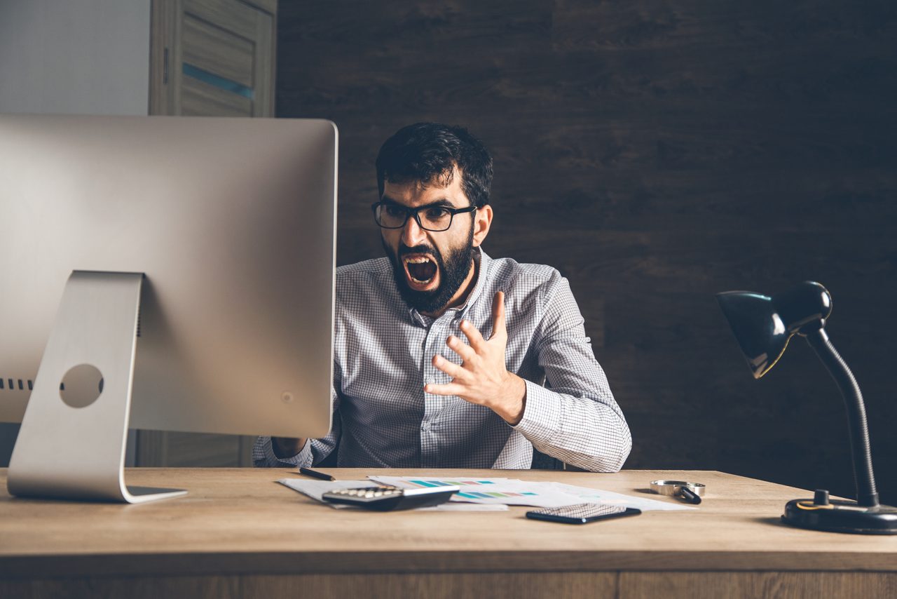 angry man with computer on the desk