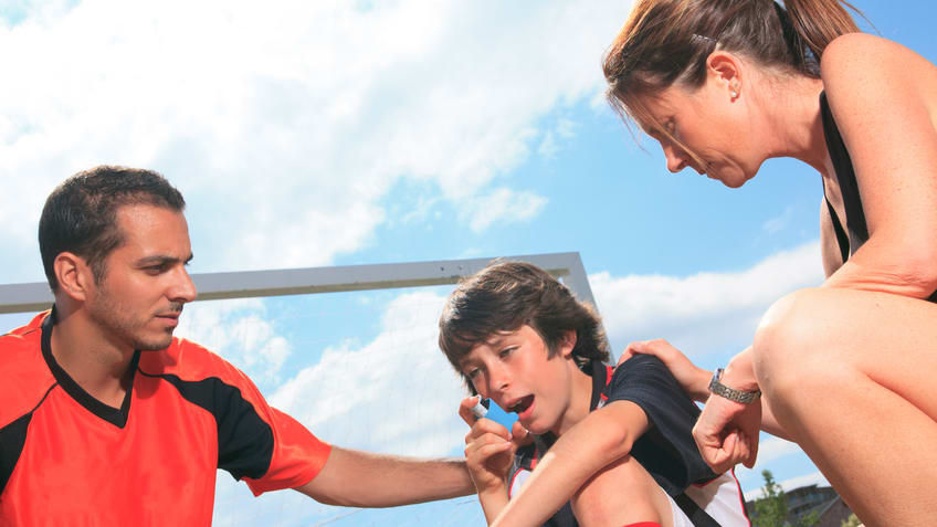 A group of people sitting on a soccer field.