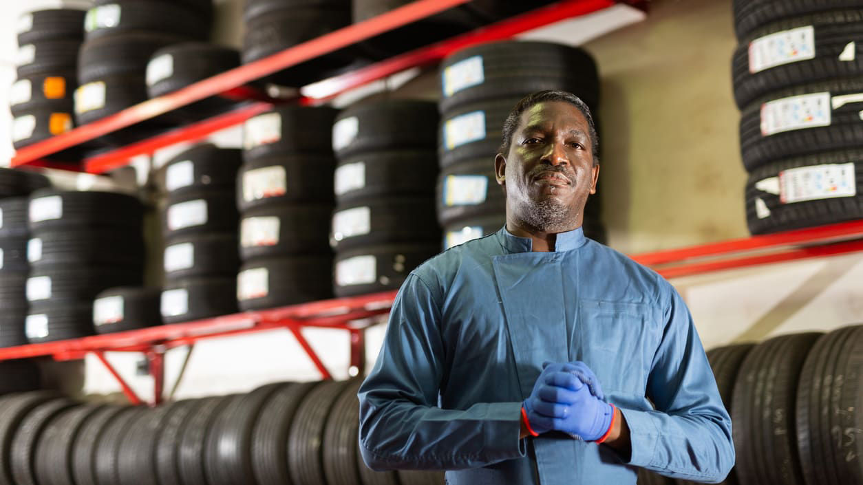 A man standing in front of a tire rack.