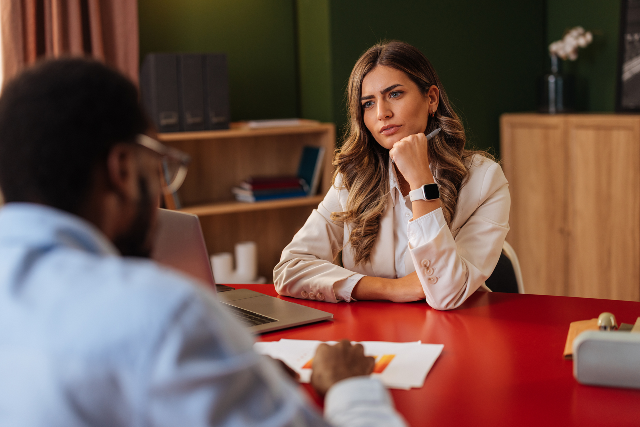 Young businesswoman interviewing a male candidate, focusing on his answers and evaluating skills for a new job position