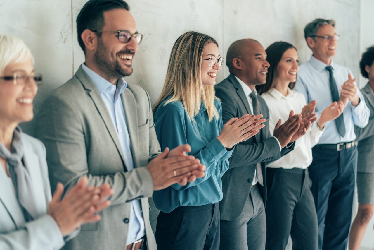 Group of people standing in a row and applauding