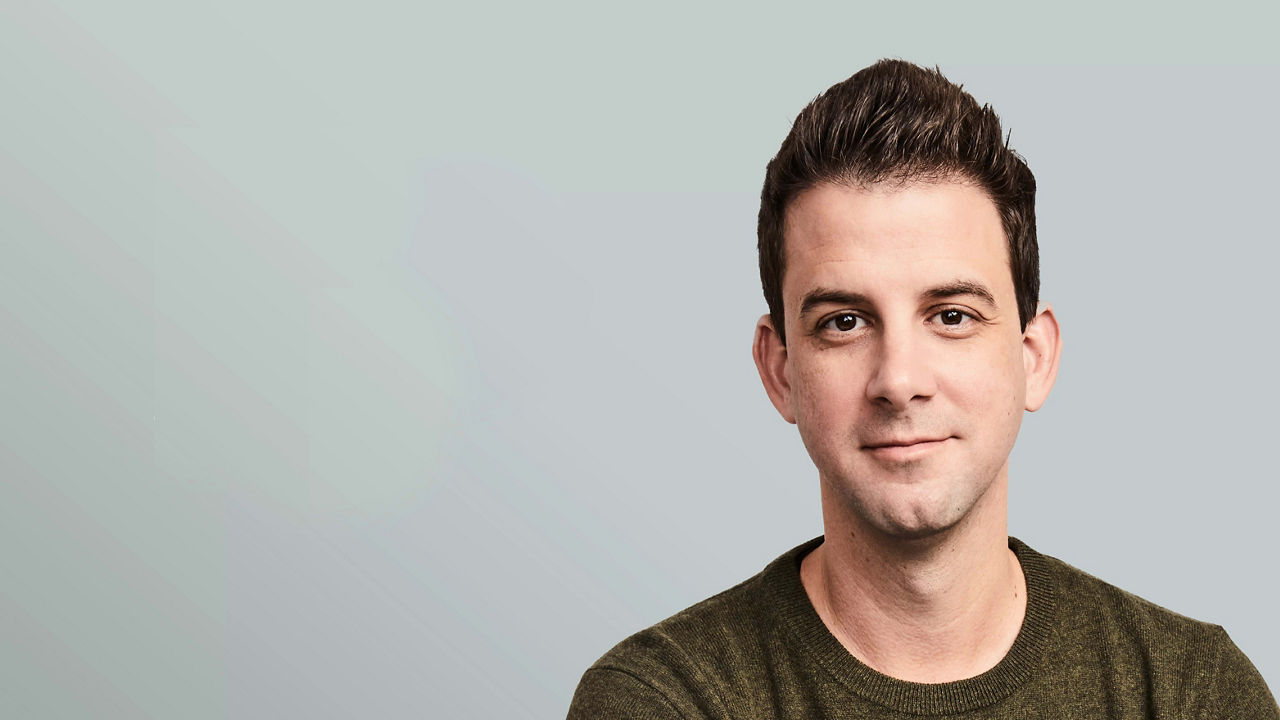 A man in a green shirt is posing for a photo.