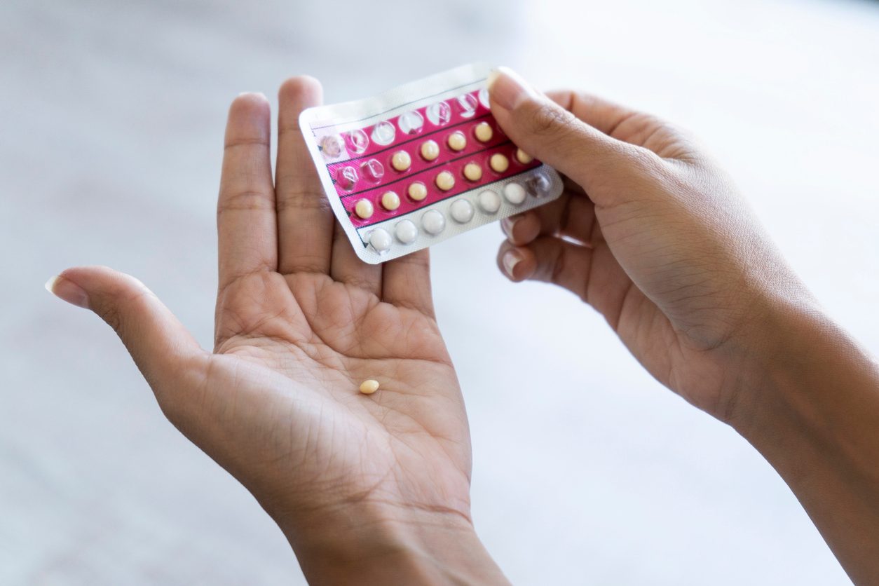 closeup of woman holding birth control pills