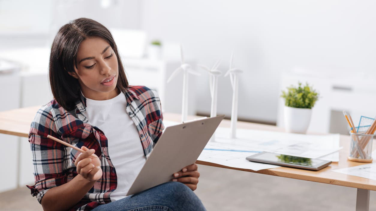 A woman sitting at a desk and using a tablet.