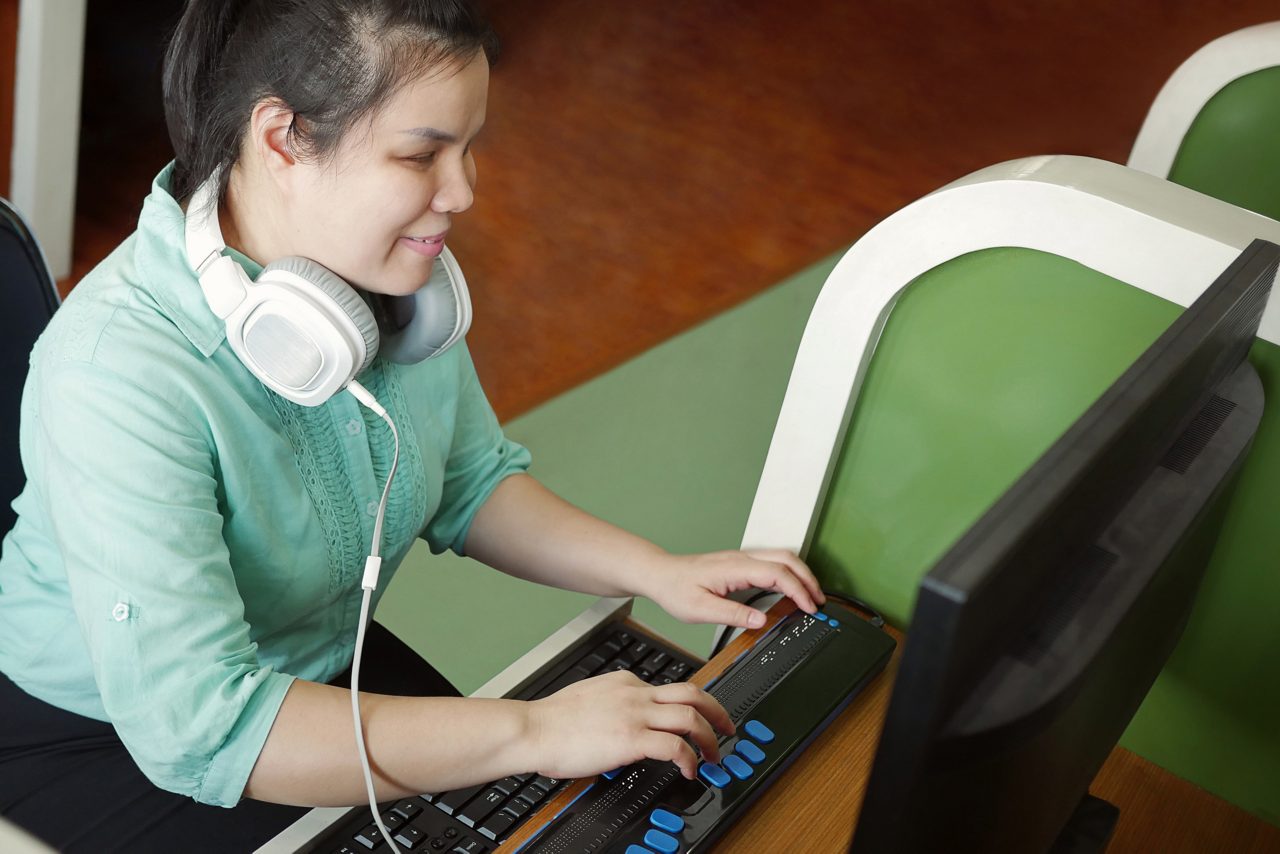 blind person typing on keyboard